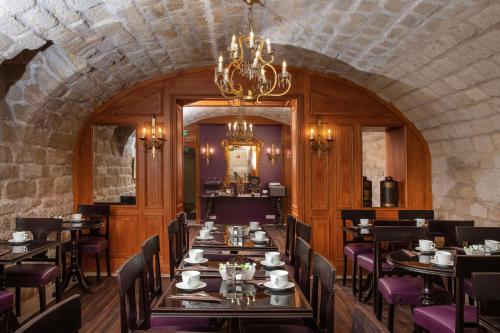 巴黎森罗特尔酒店的一间带桌椅和吊灯的用餐室