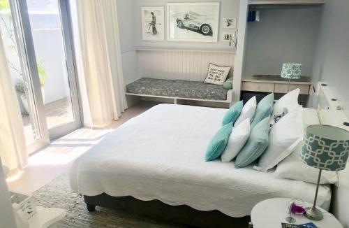 开普敦Himmelblau Boutique Bed and Breakfast的一间卧室配有一张带蓝色和白色枕头的床