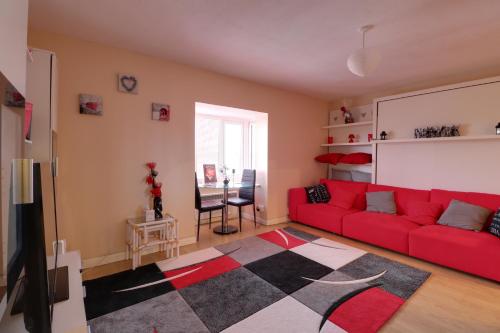 NortholtLuxury Studio Apartment的客厅配有红色沙发和地毯。