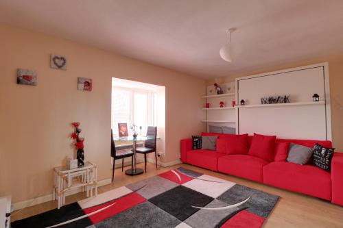 NortholtLuxury Studio Apartment的客厅配有红色的沙发和桌子