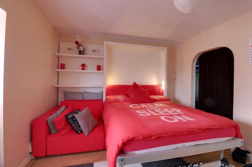 NortholtLuxury Studio Apartment的红色的床,红色沙发,位于房间里
