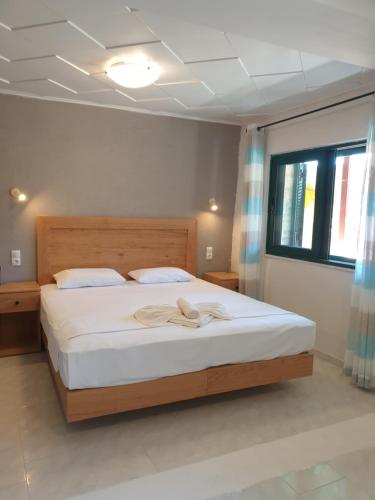 马塔拉Apartments and Studios Xenophon的一间卧室配有一张带白色床单的大床
