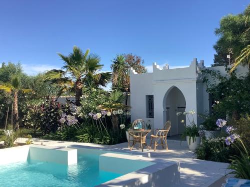 奇克拉纳－德拉弗龙特拉Kasbah Andaluz guest house的一座带游泳池和桌椅的房子