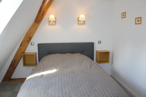 圣伊波利特Gîte Le Cep d'Or Alsace的墙上有两盏灯的房间的一张床位