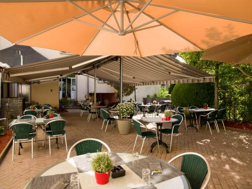 维安登维克多雨果餐厅酒店的一个带桌椅和遮阳伞的户外庭院。