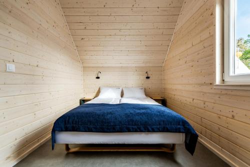 里沃Na Klifie Wypoczynek&Spa的卧室配有木墙内的一张床