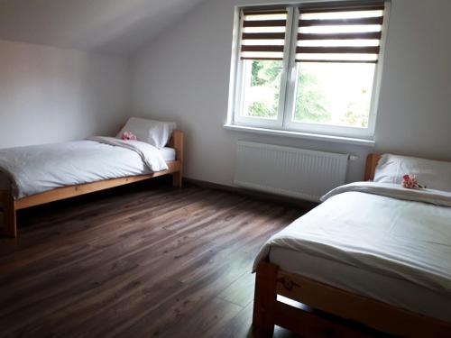 米卢夫卡Apartament w Milówce的一间卧室设有两张床和窗户。