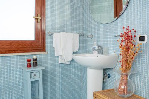 锡拉库扎特拉扎苏尔普勒密里奥酒店的蓝色瓷砖浴室设有水槽和镜子