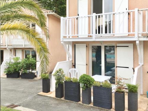 安格雷RESIDENCE LA CROISIERE- Appt Duplex 6 Personnes的白色椅子和一些植物的房子