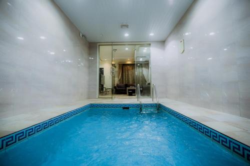 艾卜哈Layali Rahaf Chalets的客房内的大型游泳池,有蓝色的水