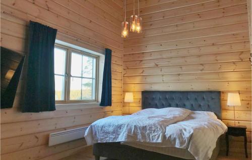 韦姆达伦Gorgeous Home In Vemdalen With Sauna的卧室配有木墙内的一张床
