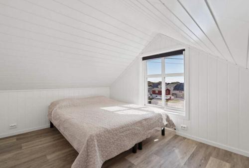 SkaftnesetRagnahuset - Koselig minihus i fiskevær的白色的卧室设有床和窗户