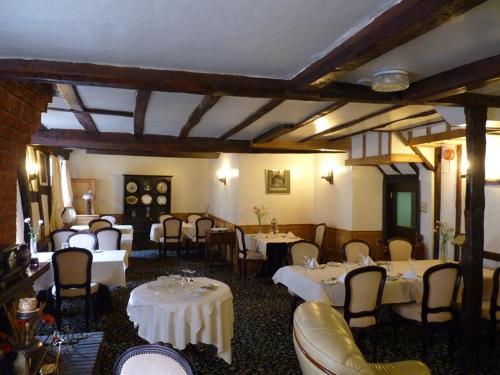 布罗姆亚德猎鹰宾馆的一间设有白色桌椅的用餐室