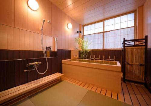 花卷市Dai Onsen Matsudaya Ryokan - Vacation STAY 67479的设有带浴缸和淋浴的浴室。