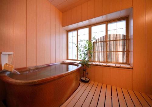 花卷市Dai Onsen Matsudaya Ryokan - Vacation STAY 67499的窗户客房内的浴缸