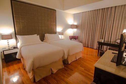雅加达蒂拉德亚酒店的酒店客房设有两张床和电视。