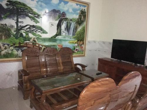 Phú HiệpNhà Nghỉ An Phát的客厅配有电视和墙上的绘画