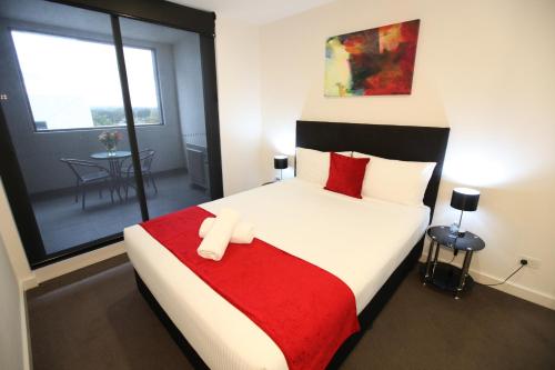 WantirnaMelbourne Knox Central Apartment Hotel Official的一间卧室配有一张带红色毯子的大床