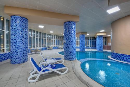 沙迦阿雅那酒店的蓝色柱子的酒店游泳池