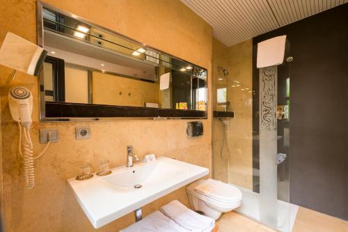 奥维多弗雷拉酒店的一间带水槽、卫生间和镜子的浴室