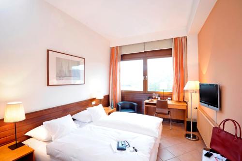 汉堡米氏霍夫酒店的酒店客房配有一张床、一张书桌和一台电视。