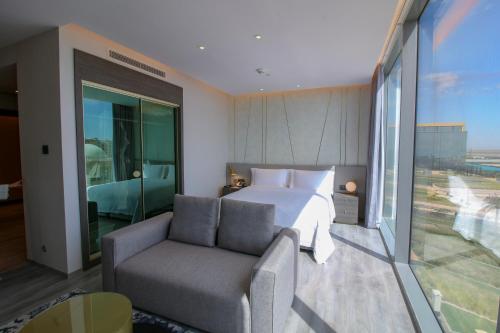 阿卜杜勒国王经济城Views Hotel & Residences的一间卧室配有一张床、一张沙发和一个窗口
