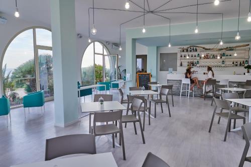蓬塔布拉切托伊尔瓦若玛热Il号滨海住宿加早餐旅馆的餐厅设有桌椅,背景人员