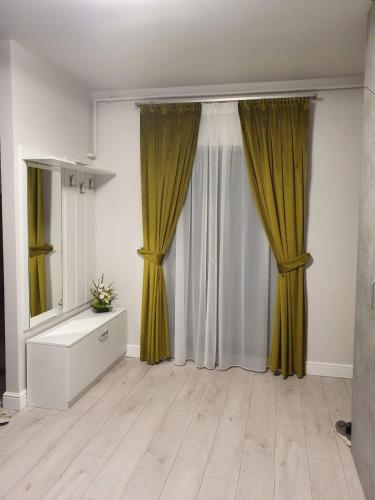 波亚纳布拉索夫Apartament Ozon Poiana Brasov的客厅配有黄色窗帘和梳妆台