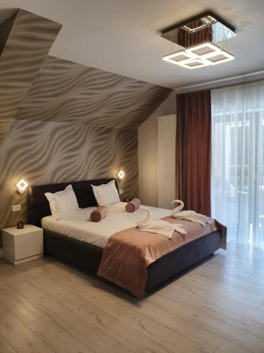 波亚纳布拉索夫Apartament Ozon Poiana Brasov的一间卧室设有一张大床和一个大窗户