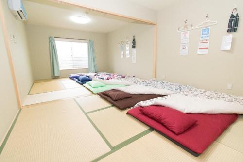 大阪切尔西彩虹旅馆的一间房间,地板上设有一排枕头