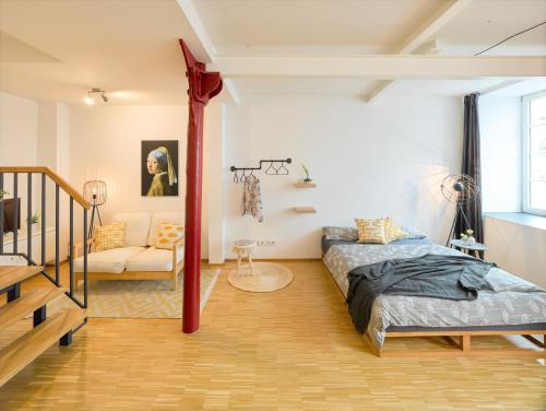 罗伊特林根☆Design Apartment Zentral☆200m vom Marktplatz☆ruhige Altstadtlage☆的一间卧室配有一张床和一个沙发