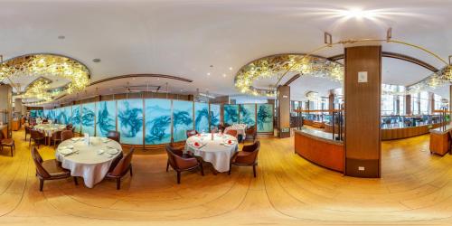 杭州天伦精品酒店西湖店的一间带桌椅的餐厅和一个大型水族馆