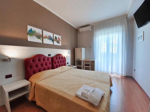 切里尼奥拉瓜德里弗格里奥Il号酒店 的一间卧室配有一张大床和红色床头板