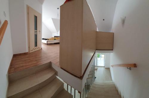波别罗沃Domy szeregowe Klif的房屋内的楼梯,拥有白色的墙壁和木地板
