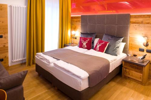 卡纳泽伊Hotel il Caminetto Sport的一间卧室配有一张带红色枕头的大床