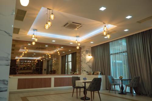 巴统Aqua Batumi Hotel & Apartments的一间带桌椅的餐厅和酒吧
