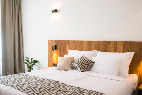 BrezovicaRoko Garni Hotel的卧室配有白色的床和木制床头板