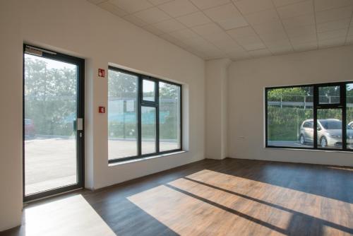 BrezovicaRoko Garni Hotel的空空房间设有大窗户和木地板
