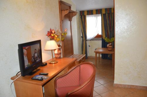 尼科泰拉码头Hotel Ristorante Antica Marina的客厅配有桌椅和电视机