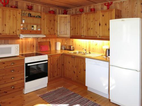 MjåvatnChalet Saglia - SOO020 by Interhome的厨房配有木制橱柜和白色冰箱。