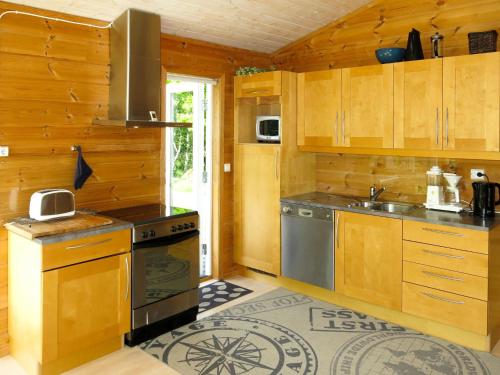 法尔松Chalet Smibakken - SOW016 by Interhome的厨房配有木制橱柜、水槽和炉灶。