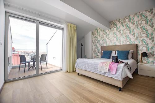 诺瓦海岸Terrazzos do Prado - Vista Ria de Aveiro的一间卧室配有一张床,阳台配有桌子