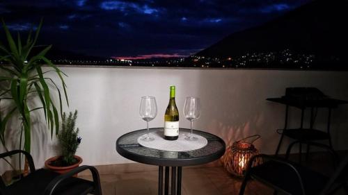 特雷比涅Apartman Sunset Trebinje的一张桌子,上面放着两杯酒和一瓶葡萄酒