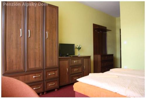维塔诺瓦Alpský dom Vitanová的一间卧室配有一张床、一个梳妆台和电视。