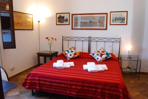 莱切B&B Corte Barocca的一间卧室配有红色的床和毛巾