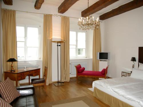 雷根斯堡金色克鲁兹酒店的一间卧室配有一张床、一张桌子和一把椅子