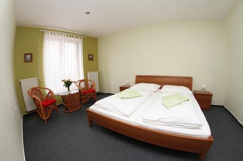 斯祖贝莱克米洛汀旅馆的一间卧室配有一张大床和一张桌子及椅子
