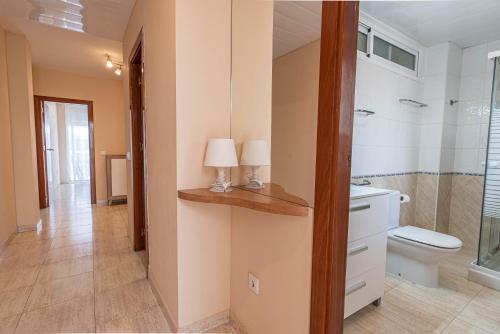 卡拉费尔Apartaments Costamar Calafell的浴室设有卫生间和2盏台灯。