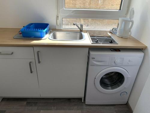 FrensdorfGroßes, modernes Apartment im Souterrain的厨房配有水槽和洗衣机