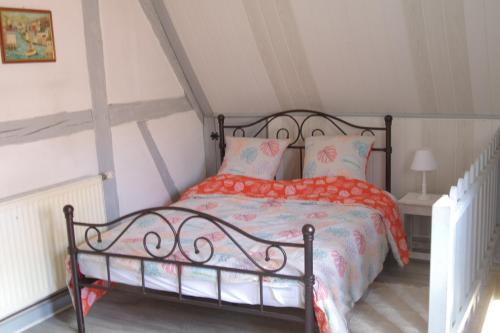 BernardvilléGîte de charme au coeur du vignoble alsacien的一间卧室配有一张带橙色和蓝色棉被的床